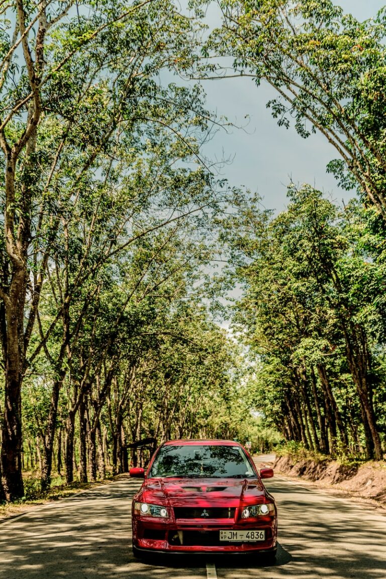 red Mitsubishi vehicle under blue sky during daytime